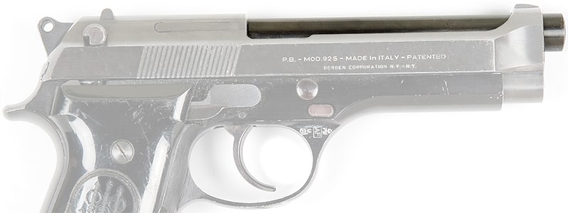 Closeup on the Beretta 92's slide and barrel. Its slide is mostly cut out, exposing most of the barrel.