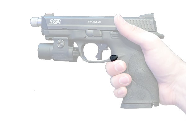 Person holding pistol, with emphasis on the magazine release for unloading.