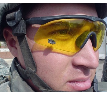 A man, wearing eye protection that has a ricochet lodged in it. His eyes were saved from certain doom.