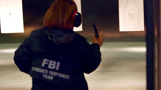 An FBI agent reloading her pistol.